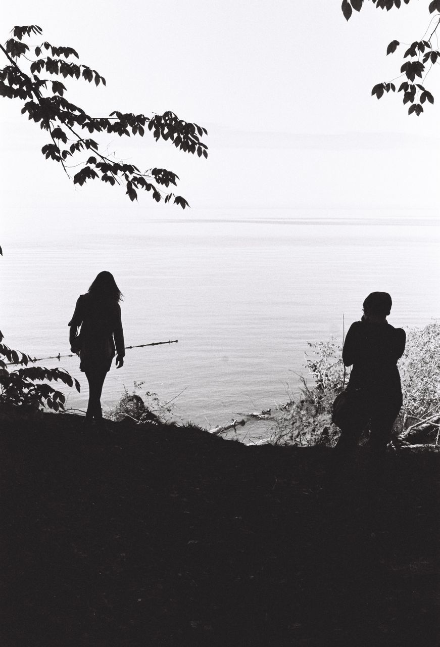 silhouette, sea, real people, full length, nature, water, horizon over water, rear view, men, standing, scenics, tranquil scene, two people, outdoors, beauty in nature, beach, sky, tranquility, lifestyles, togetherness, day, vacations, flying, tree, people