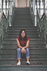 Full length portrait of woman sitting on steps