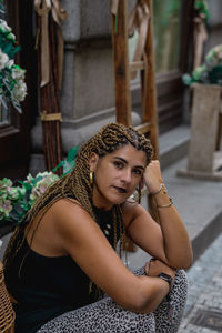 Portrait of young woman sitting outdoors