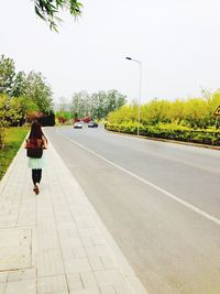 Full length of woman walking on footpath