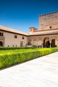 Lawn by building against clear blue sky