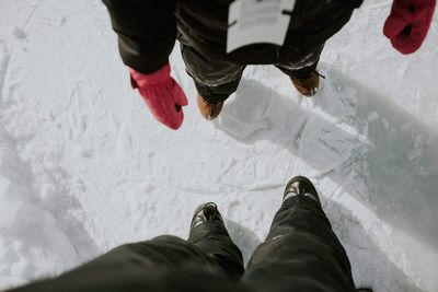 Low section of people standing on snow covered