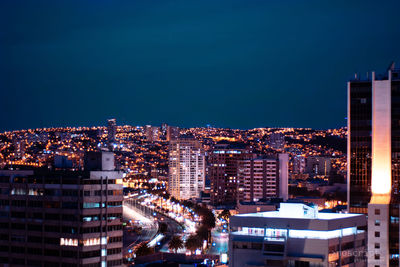 High angle view of illuminated buildings against clear sky at night