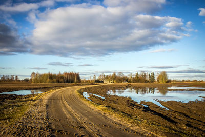 Road by lake against sky