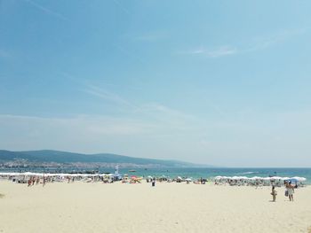 Group of people on beach against sky