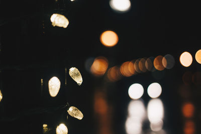 Low angle view of illuminated lights against sky at night