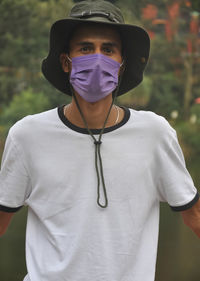 Portrait of man wearing hat and mask outdoors