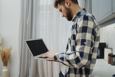Young man using laptop at home