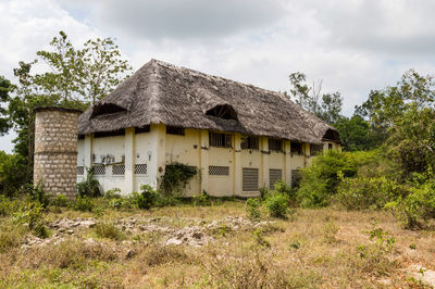 Abandoned house on field against sky