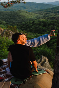 Side view of woman sitting on mountain