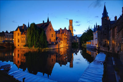 Reflection of buildings in city at dusk