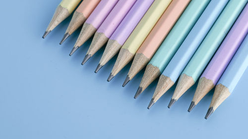 Directly above shot of colored pencils on blue background