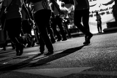 Low section of people walking on city street