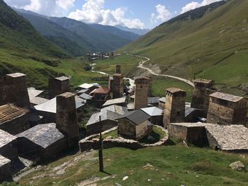 Scenic view of field and houses against sky