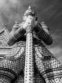 Low angle view of statue of building against cloudy sky