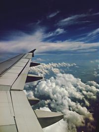 Airplane flying over cloudscape against sky