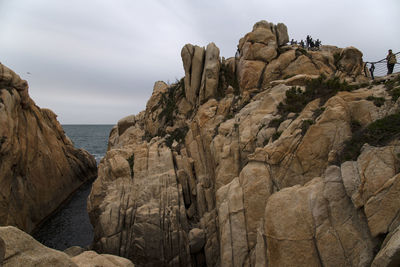 Rock formations in sea against sky