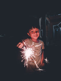 Full length portrait of smiling boy at night