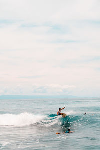 Man surfing on sea against sky