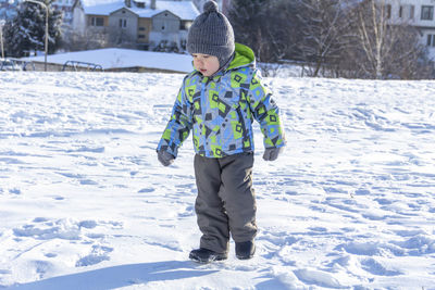 Full length of boy walking on snow covered land