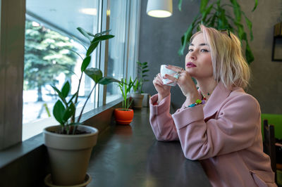 Young woman is drinking coffee in a cafe.