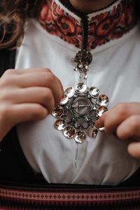 Midsection of woman holding jewelry