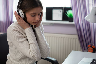 Young woman using mobile phone while sitting at home