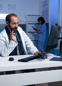 Doctor working on desktop pc at clinic