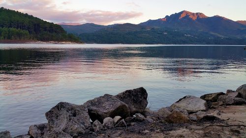 Scenic view of lake by mountains against sky