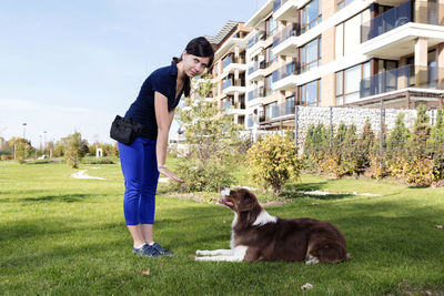 Young woman with dog on field against sky