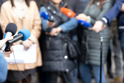 Journalists at news conference or media event, microphone in the focus