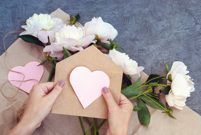 High angle view of hand holding white roses