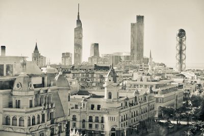 Buildings in city against clear sky