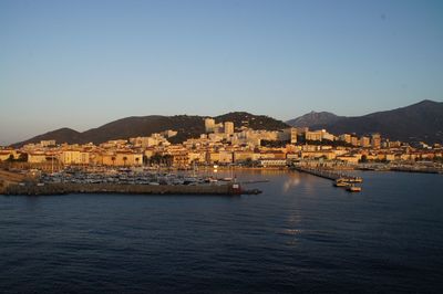 Scenic view of sea and buildings against clear sky