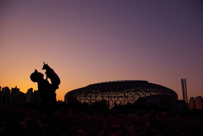 Silhouette of man with dog against sky