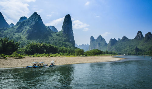 Scenic view of river and mountains against sky