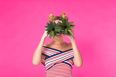 Rear view of woman with pineapple against yellow background