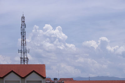 Low angle view of communications tower and buildings against sky