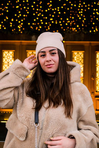 Portrait of smiling woman against christmas decoration during winter