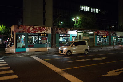 Cars on illuminated street in city at night