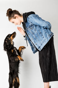 Woman with dog standing against white background