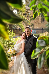Portrait of wedding couple standing at park