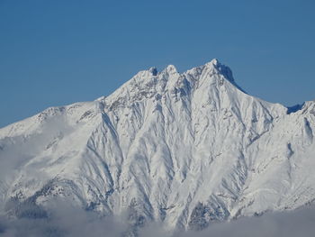 Scenic view of snowcapped mountains against clear blue sky