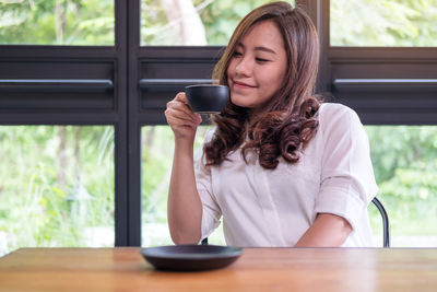 Woman drinking coffee cup on table in cafe