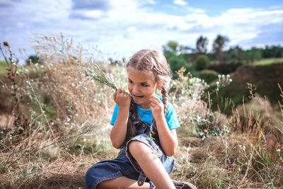 Full length of girl sitting on field