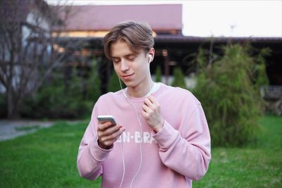 Young man using mobile phone in grass