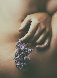 Hand with lilac flower between female body