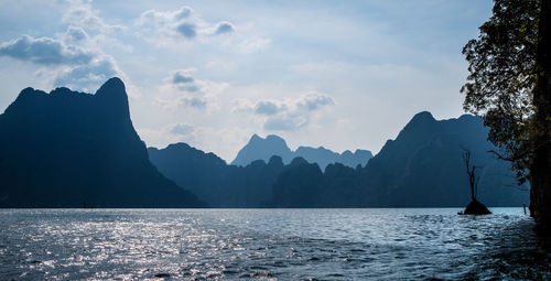 Scenic view of sea and mountains against sky