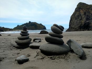 Stack of stones on beach against sky