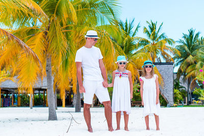 Women standing by palm trees